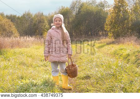 Little Girl In Yellow Ribber Boots With Basket Outdoor In Nature. Autumn Concept