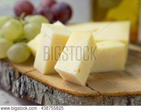 Light Meal With Sliced Cheese Next To A Bunch Of White And Red Grapes