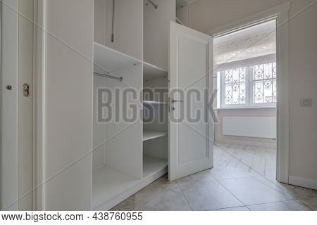 Rows Of Shelves And Clothes Hangers In Empty Big Wardrobe Room In Modern Apartment Or Hotel