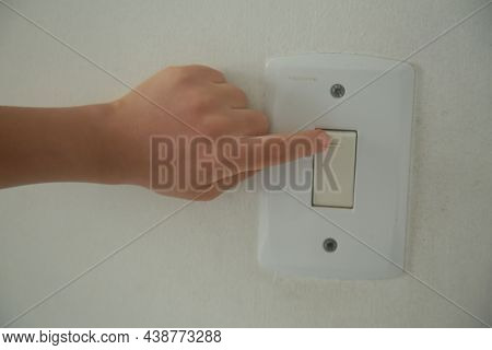 Salvador, Bahia, Brazil - November 6, 2021: A Child's Hand Is Seen Turning On A Light On An Intrrupt