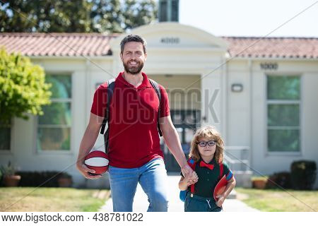 American Father And Son Walking Trough School Park. Parent Take Child To School. Pupil Of Primary Sc