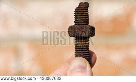 Old Rusty Bolt, Iron Rod With Screw Threads, In Hand. Rusted Mechanical Components. Holding Threaded