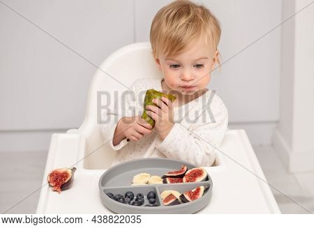 Caucasian Blonde Toddler Eating From Silicone Plate Fresh Pear, Fruits, Berries, Having Meal On Whit
