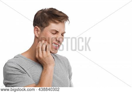 Despaired Millennial Caucasian Attractive Male Presses His Hand To Cheek And Suffers From Toothache