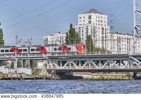 Kaliningrad, Russia - September 11, 2021: Electric Train Lastochka Going On Two-tier Railway Bridge 
