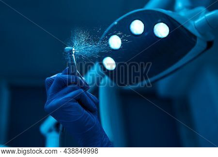 Close-up Of Dental Drill With Splashing Water Against The Background Of The Included Lamp Light In D