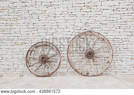 Two Vintage Wooden Wheels. Antique Masonry In Beige Shades. Beautiful Textured Background From Natur