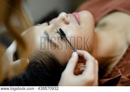 Beautician giving eyelash treatment to a customer at a beauty salon