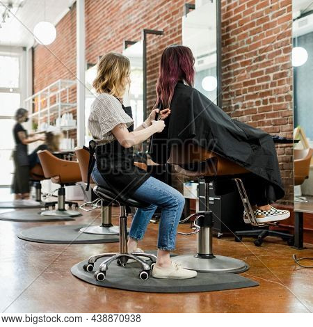 Hairstylist giving a haircut to a customer at a beauty salon