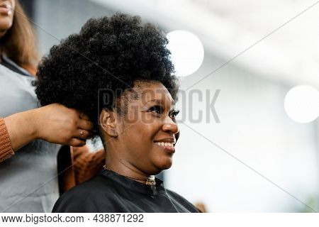 Hairstylist giving a finishing touch for the customer's hairdo