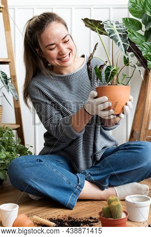 Woman repotting a houseplant inside of her house