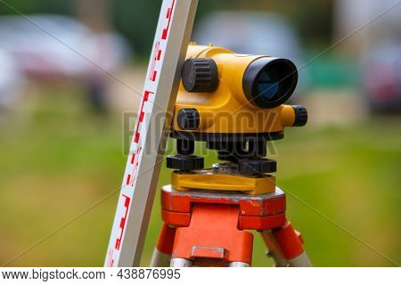 Close-up View Of Cheap Geodesy Level Device With Tower Ruler Outdoors At Daylight