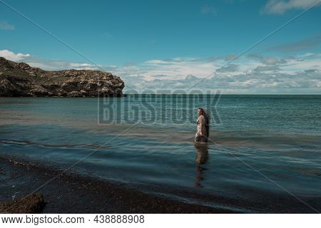 Girl With Long Hair Posing In Water. Treavel By The Sea