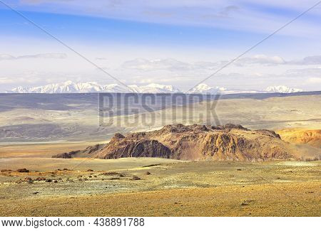 Chui Valley In The Altai Mountains. Rocky Cliffs, A Rolling Plain In The Distance Against The Snowy 