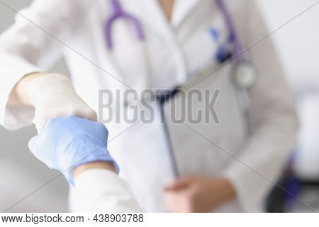 Focus On Practitioners Demonstrating Fist Bump Gesture With Hands In Gloves. Healthcare And Medicine