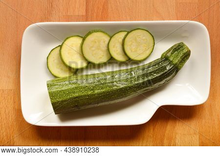 Top View Of Half Of Zucchini And Fiew Slices On White Plate