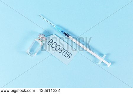 Concept For Corina Virus Booster Vaccination With Vial And Syringe On Blue Background