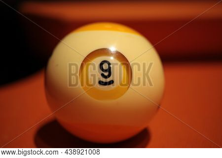Pool Ball Number 9 Extreme Close-up On Blurred Background Of American Billiards Playing Surface