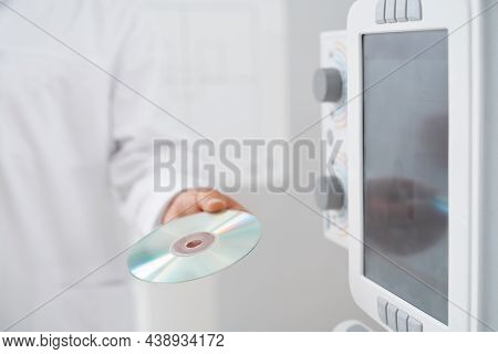 Crop Of Male Doctor Holding Plate With Silver Cd Plate With Information And Results After Ultrasound