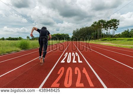 The Start Into The New Year 2022. Start Up Of Runner Man Running On Race Track Go To Goal Of Success
