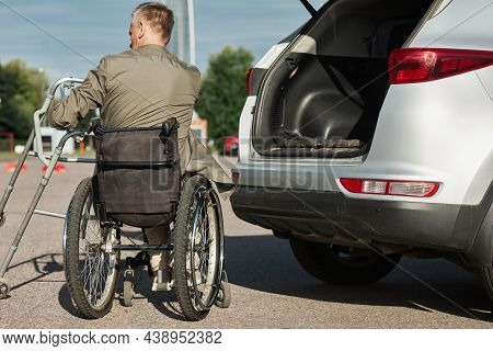 Back View Of Adult Man Using Wheelchair Unloading Car In Parking Lot Outdoors, Copy Space