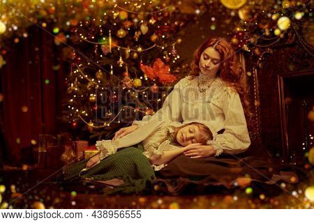 Christmas night. Vintage portrait of happy mother lulling her beloved daughter, sitting by a New Year's tree on Christmas night. 