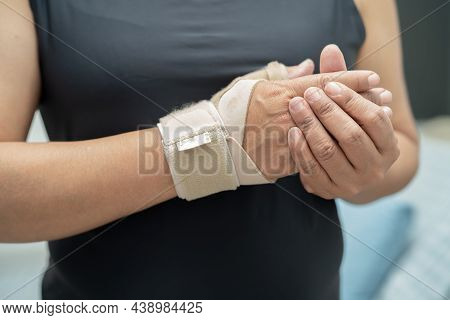 Asian Middle-aged Lady Woman Use Elastic Bandage To Treating De Quervain Syndrome At Hand And Finger
