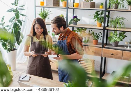 Young Florists With Coffee Using Gargets In Flower Shop