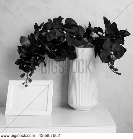 Composition With Tropical Orchid Flowers In Vase And Photoframe With Space For Text On Cabinet By Wa