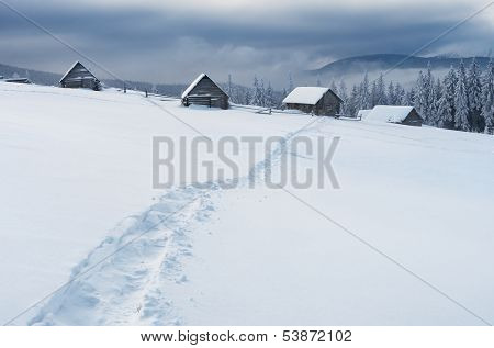 Winter landscape with a path in the snow. Hut in a mountain valley. Carpathians, Ukraine, the valley Kukul