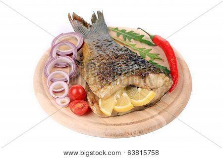 The tail of fried fish on a wooden plate
