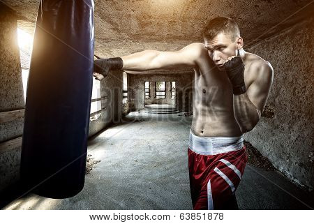 Young man boxing workout in an old building