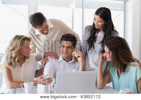 Casual smiling business team congratulating their colleague in the office