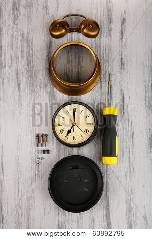 Repair clock on wooden background