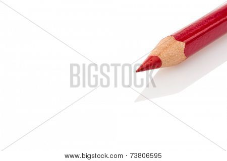 a red colored pencil lies on a reflecting plate
