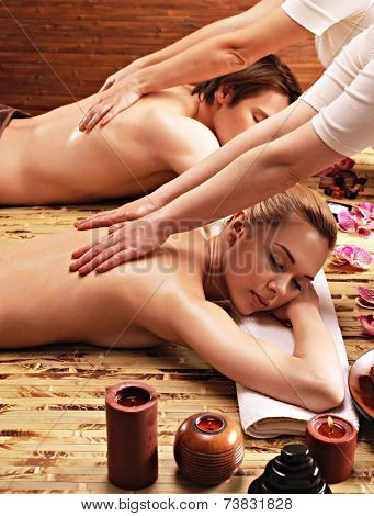 Attractive couple lying  in a spa salon enjoying a deep tissue back massage together.