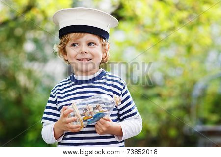 Happy Kid In Skipper Uniform Playing With Toy Ship