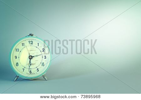 Old alarm clock on blue background