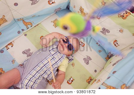 Playful Kid In His Bed With Sunglasses
