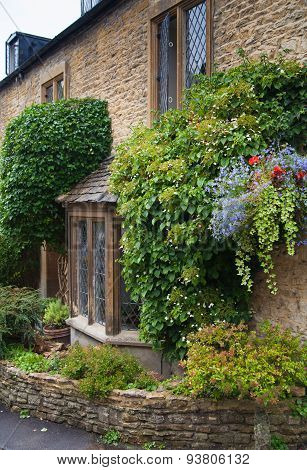 CHIPPENHAM, UK - AUGUST 9, 2014: Castle Combe, unique old English village. Old house and park