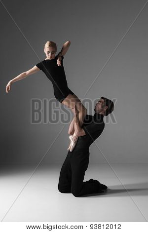 two young modern ballet dancers on gray studio background
