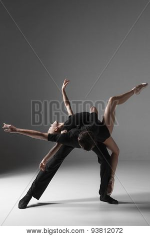 two young modern ballet dancers on gray studio background