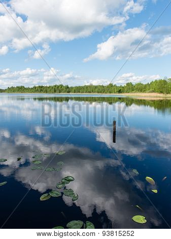White Clouds On The Blue Sky Over Blue Lake