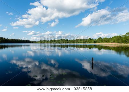 White Clouds On The Blue Sky Over Blue Lake