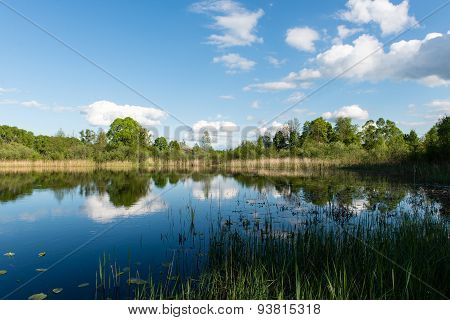 White Clouds On The Blue Sky Over Blue Lake