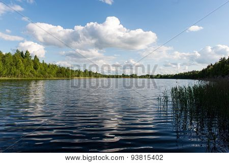 White Clouds On The Blue Sky Over Blue Lake