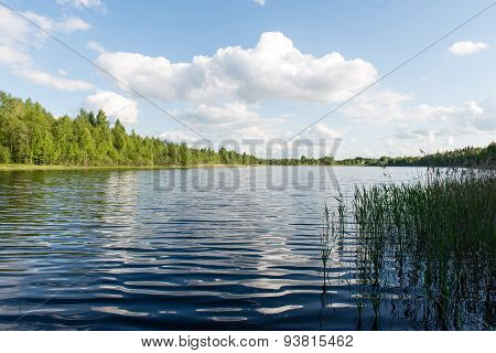 White Clouds On The Blue Sky Over Blue Lake