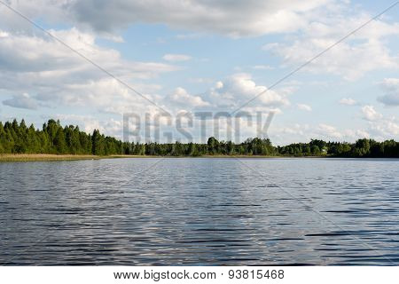 White Clouds On The Blue Sky Over Blue Lake