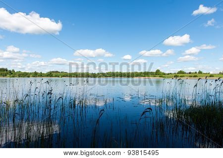 White Clouds On The Blue Sky Over Blue Lake