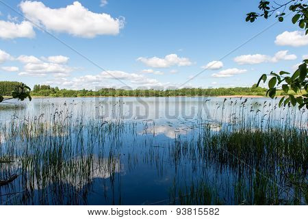 White Clouds On The Blue Sky Over Blue Lake